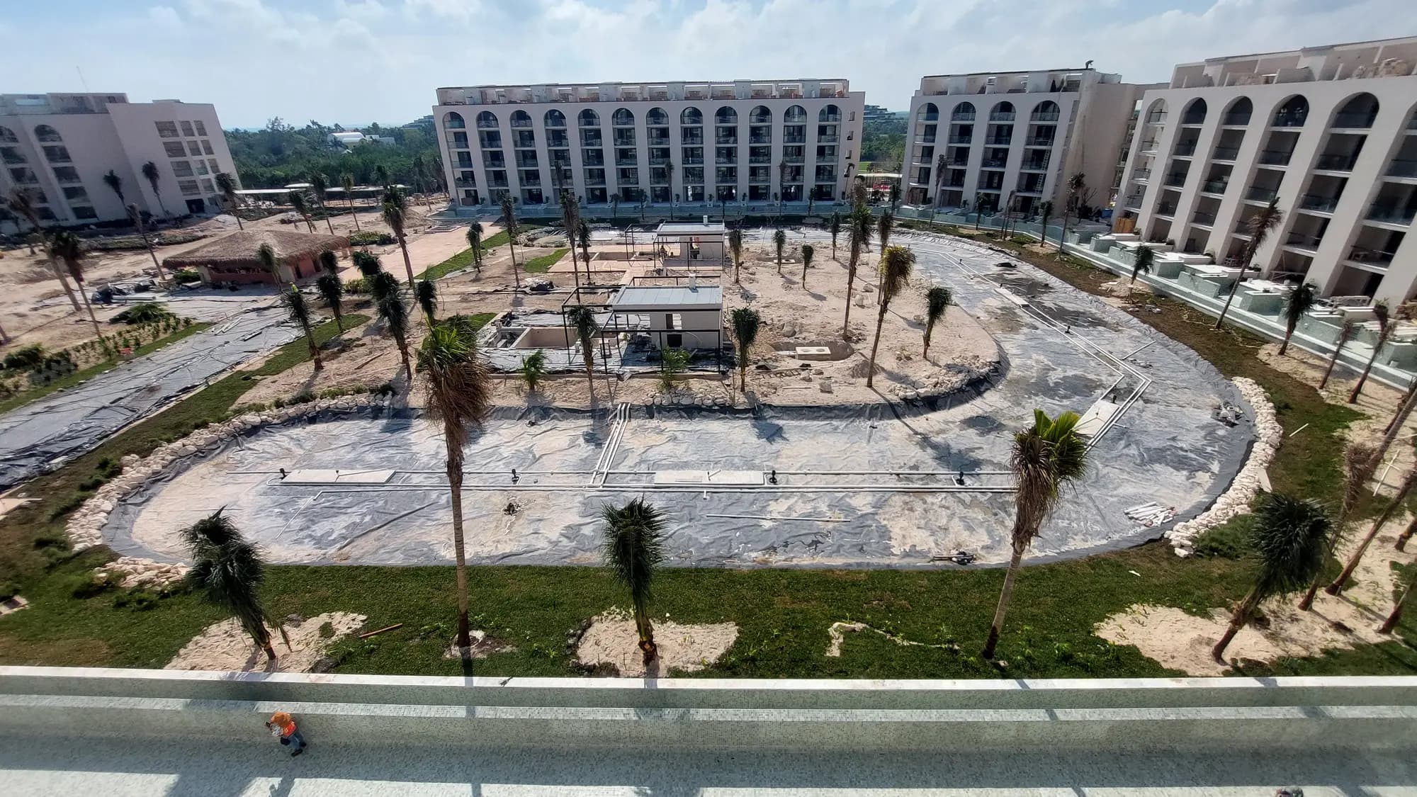Jardines y alberca central de un resort en construcción en la Riviera Maya